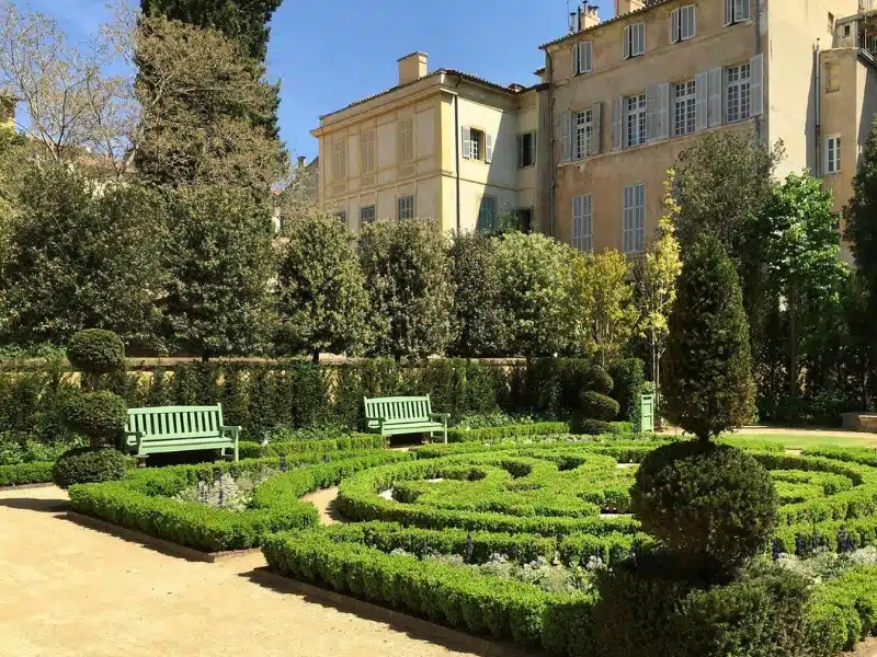 formal parterre garden backed by a large stone building with white shutters