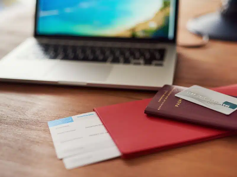 Shot of travel documents and a laptop on a table.