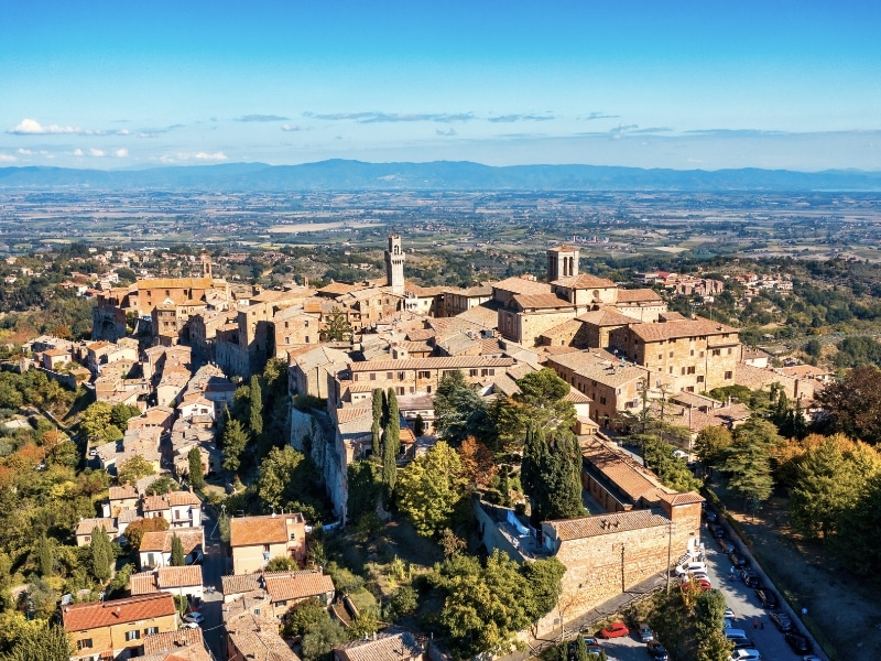 Italian hill village of honeyed stone and teracotta roofs