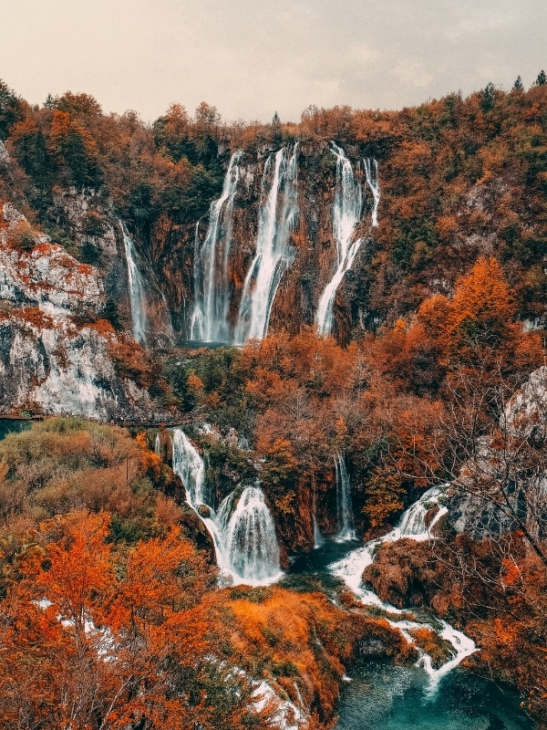 Plitvice Lakes in autumn with bright foliage surrounding the waterfalls