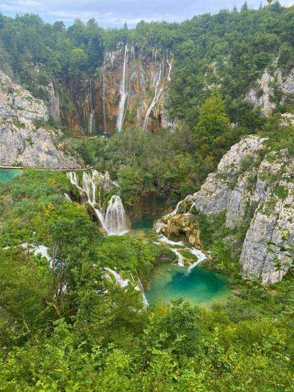 multiple waterfalls surrounded by green trees and vegetation