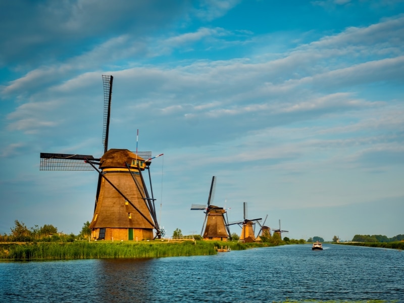 Netherlands rural lanscape with windmills at famous tourist site Kinderdijk in Holland on sunset with dramatic sky