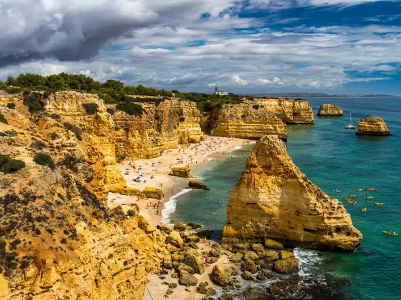 Navy Beach (Praia da Marinha) with flying seagulls over the beach, located on the Atlantic coast in Lagoa Municipality, Algarve.