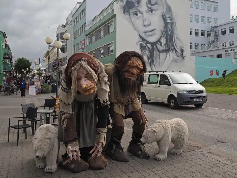 Two trolls and polar bears figurine on main street downtown Akureyri city center Iceland