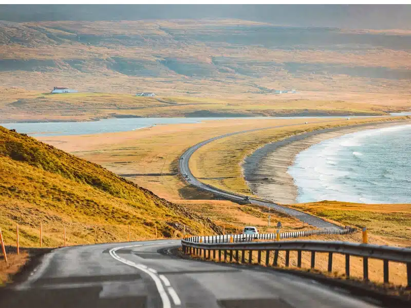 Empty road trough Iceland near the sea on a beautiful sunny autumn day.