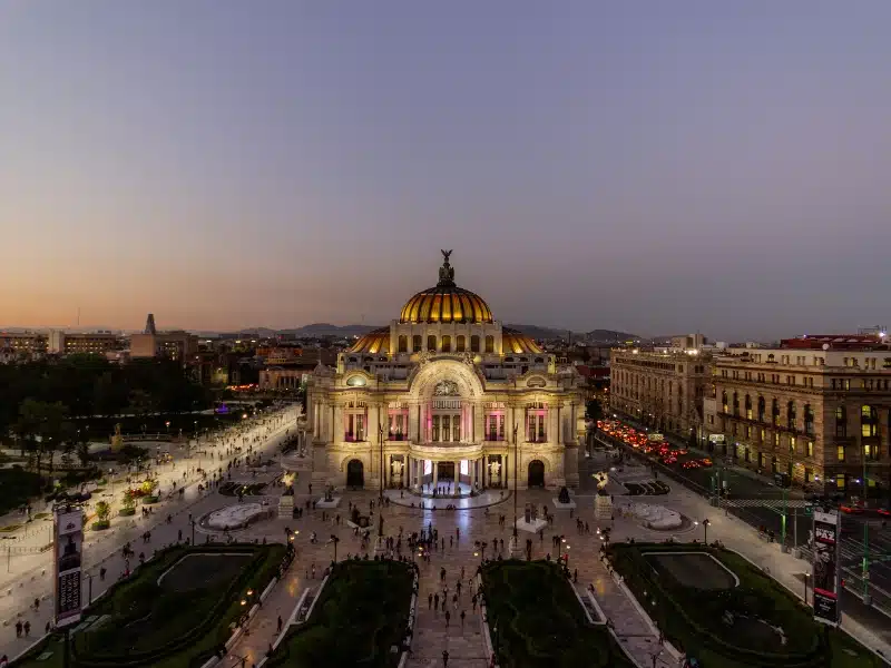 Beautiful aerial view of Palace of Fine Arts from Mexico City under sunset sky. Astonishing dusk skyline above Hispanic palace in crowded street. Mexican landmarks