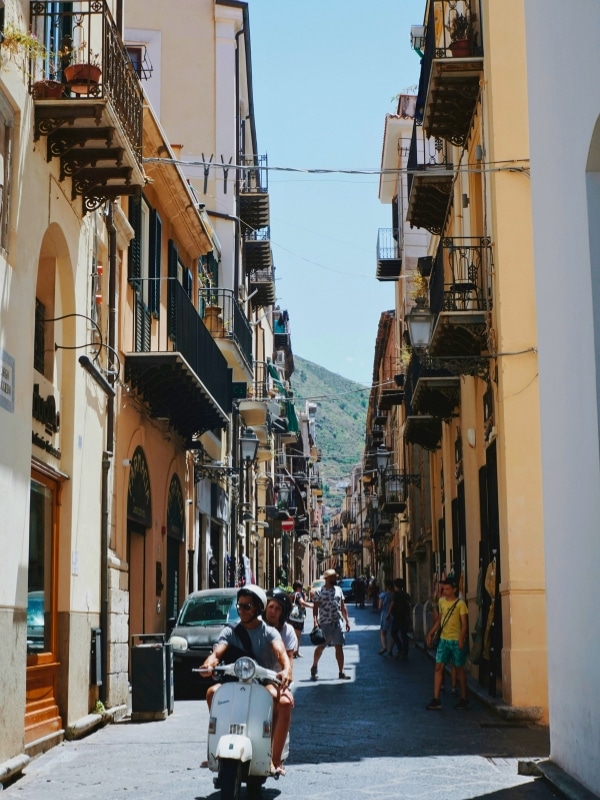 Man riding a vespa in Sicily. Cefalù, Sicily.
