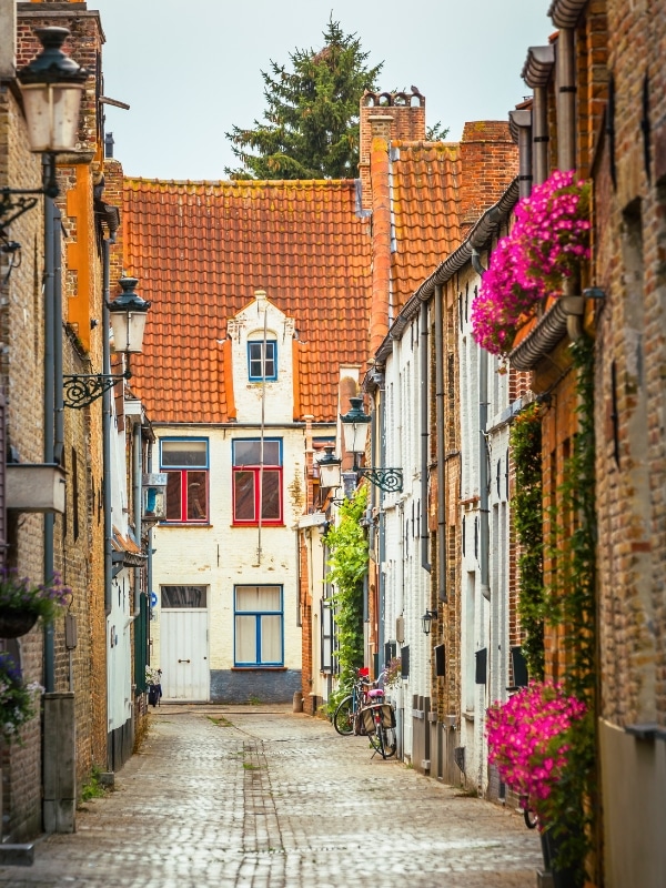 Street corner in beautiful Bruges with flowers, flemish architecture, Belgium