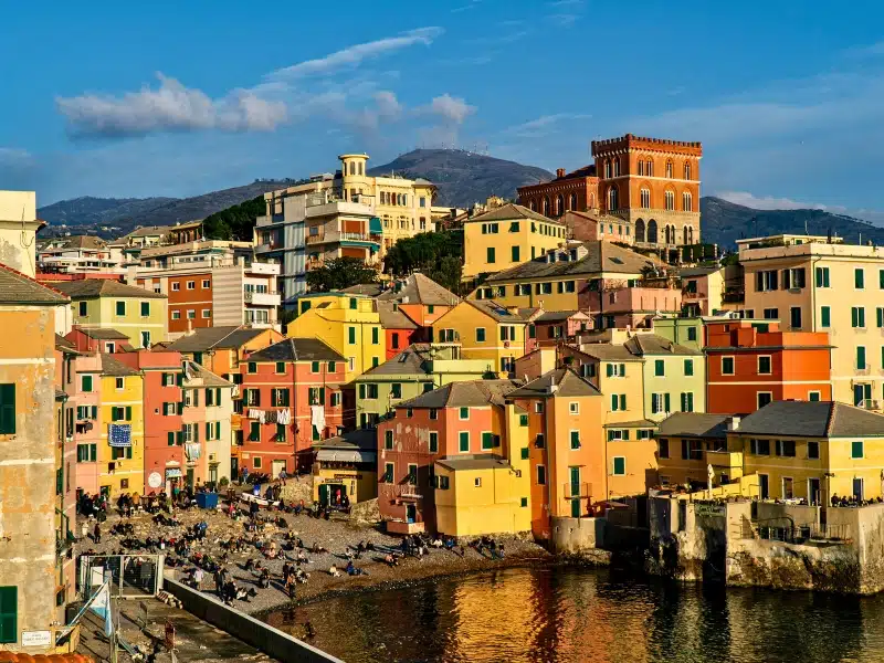 Brightly painted houses by a small pebbly city beach