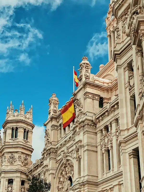 Red and yellow Spanish fly flying from the Jerónimos Monastery in  Madrid, Spain