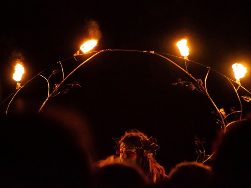 Woman holding a ring of fire on a dark night