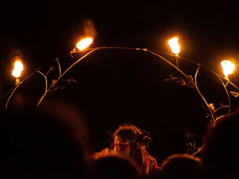 Woman holding a ring of fire on a dark night