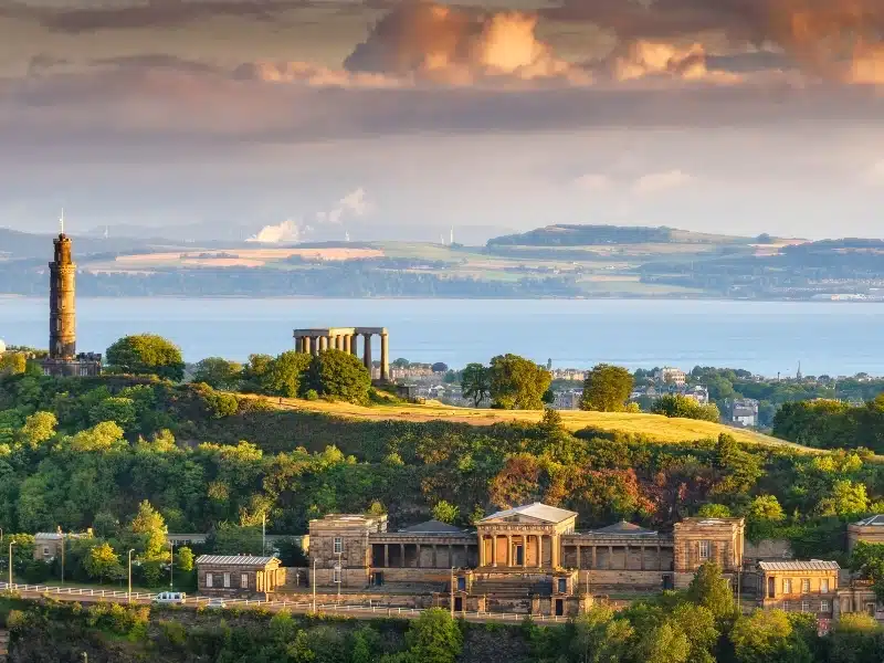 View across a hillside of National Monuments in Edinburgh across to the Firth of Forth