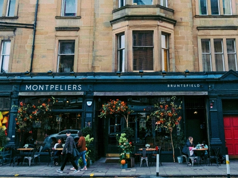 City ventre cafe with a green frontage displaying autumn foliage and pumpkins
