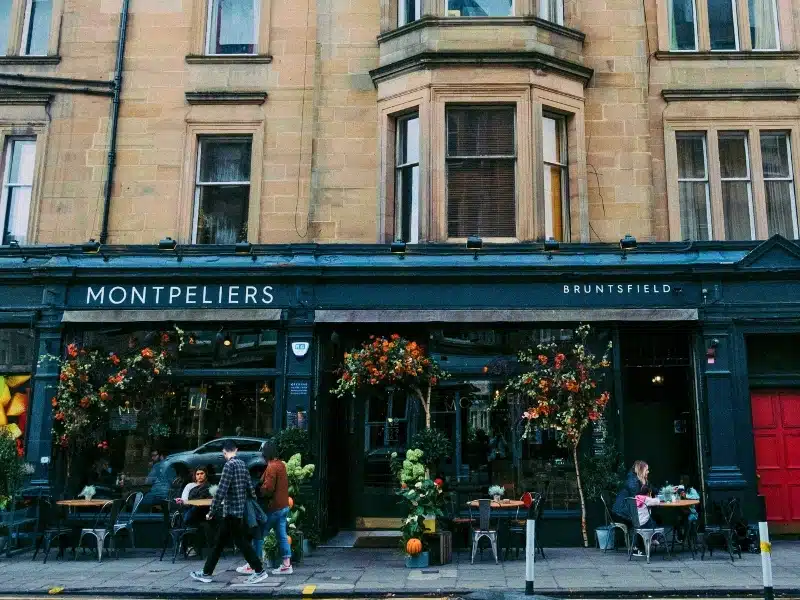 City ventre cafe with a green frontage displaying autumn foliage and pumpkins