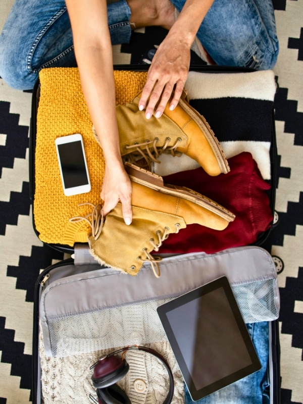 open suitcase fill of cosy woolens in autumnal colors