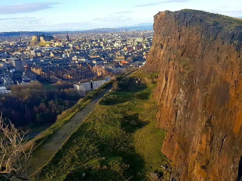 high red sandstone cliff overlooking an autumnal city