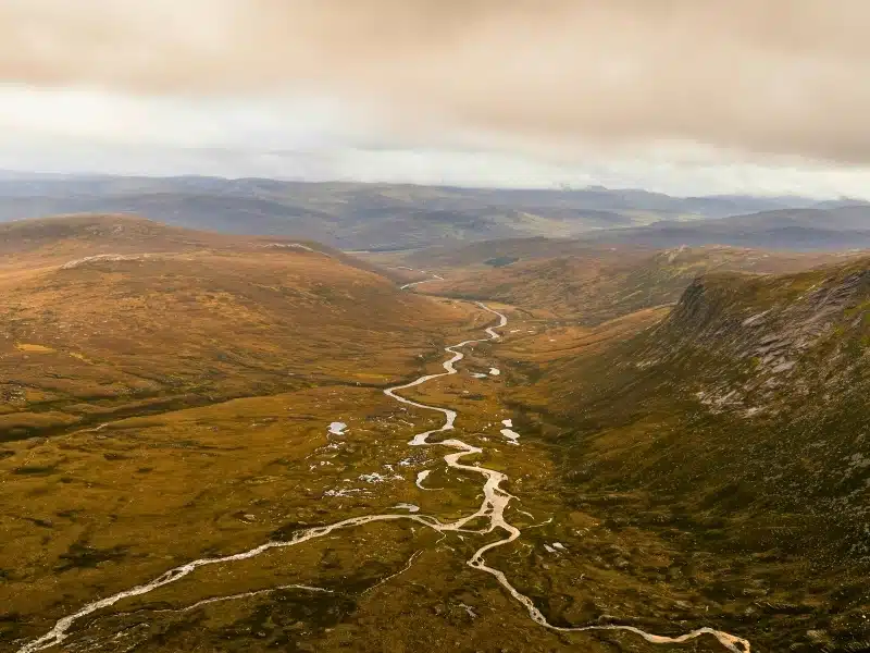 view across a wide valley with a river running through it