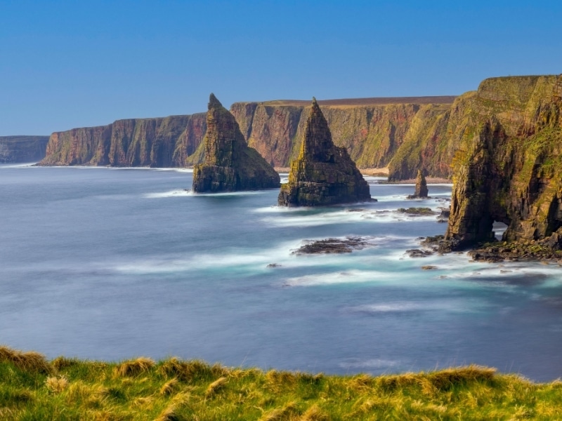 Sea stacks and high cliffs with a blue sky