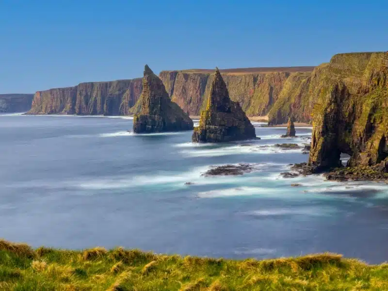 Sea stacks and high cliffs with a blue sky