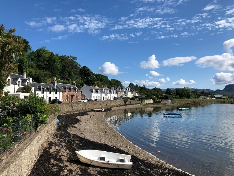 Pretty waterside village of white houses with a small boat in the foreground