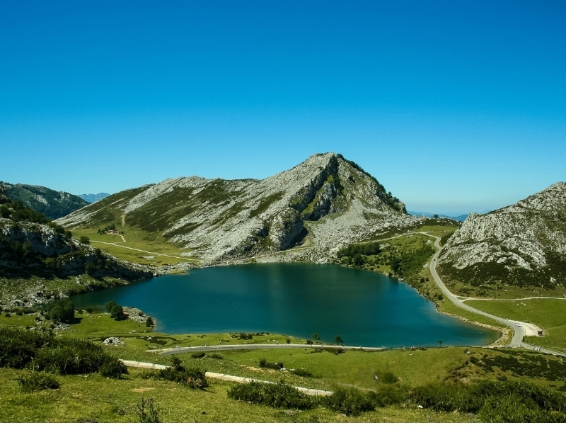 Road traverses a lake high in the mountains of Northern Spain