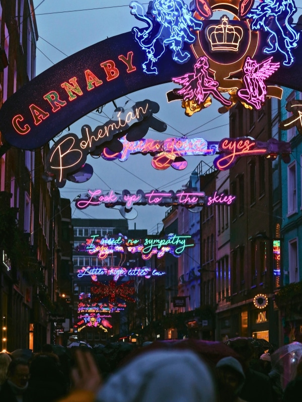 Iconic London street after dark with neon light displays