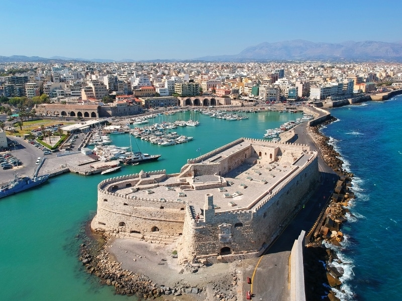 Ariel view over a city and harbor with a large defensive fortress protecting the harbor