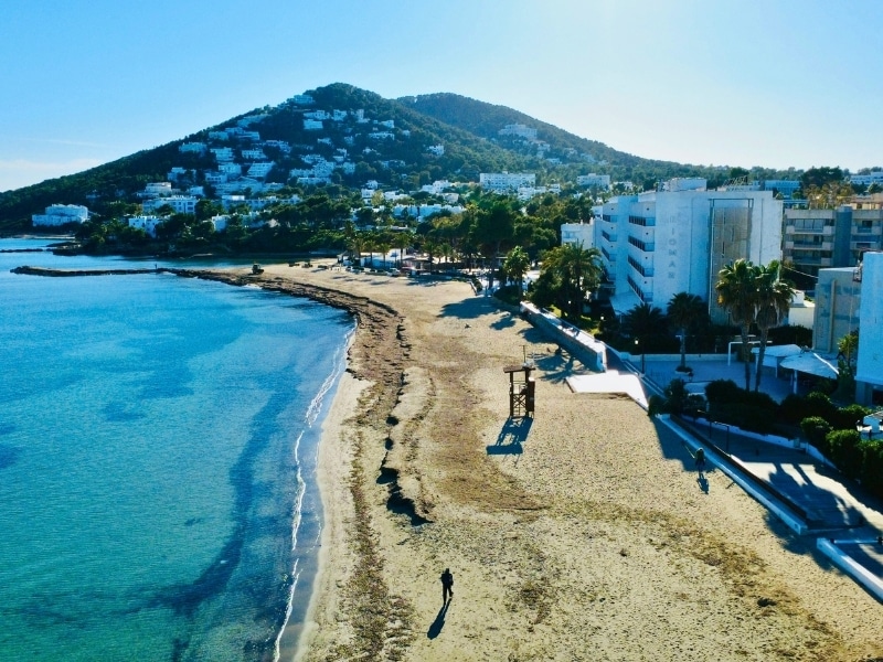Deserted winter beach backed by a town of white houses among wooded hillsides