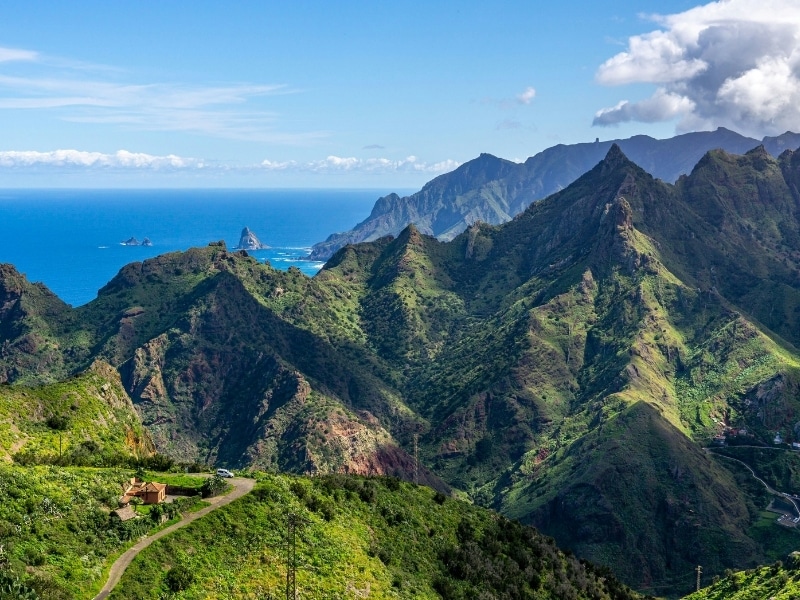 Dramatic peaks covered in green foliage with the blue sea in the distance