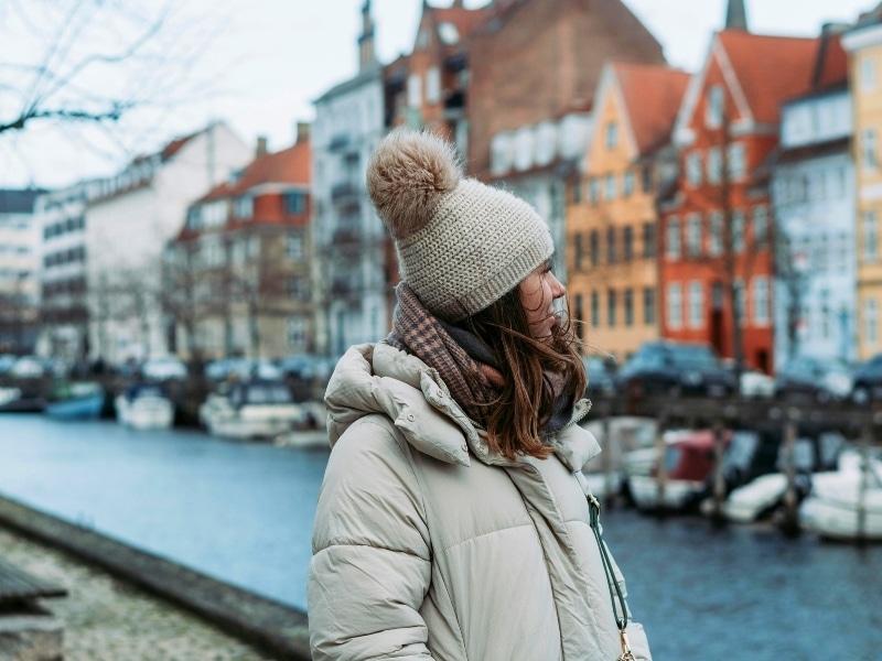 Woman wearing a down jacket. andknitted hat in Copenhagen, Denmark