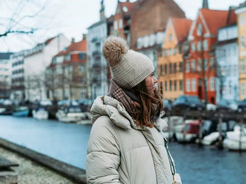 Woman wearing a down jacket. andknitted hat in Copenhagen, Denmark