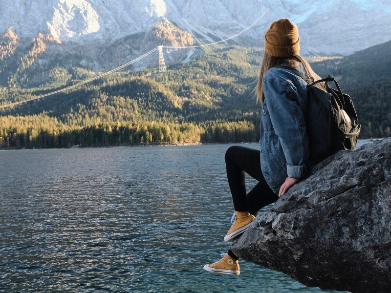 Woman sitting on a rock overlooking the Eibsee in Bavaria