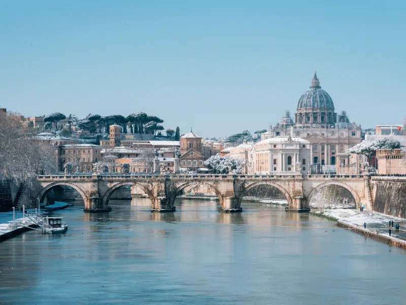 Ponte Sant'Angelo and St. Peter's Basilica in the snow, in Rome, Italy.