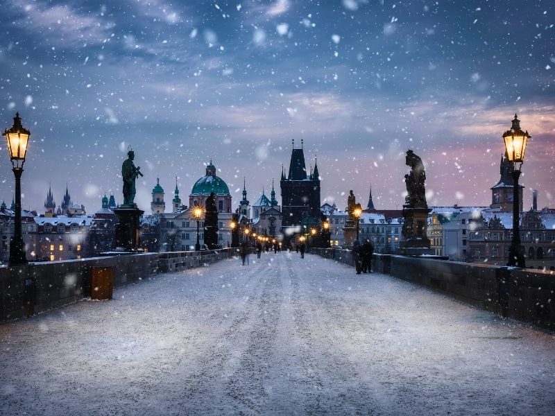View over the snow covered Charles Bridge in Prague to the skyline of the old town during a cold winter morning, Czech Republic