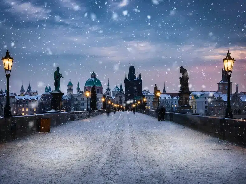 View over the snow covered Charles Bridge in Prague to the skyline of the old town during a cold winter morning, Czech Republic