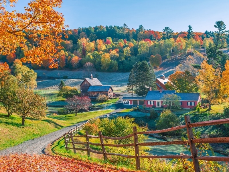An early autumn foliage scene of houses in Woodstock, Vermont mountains
