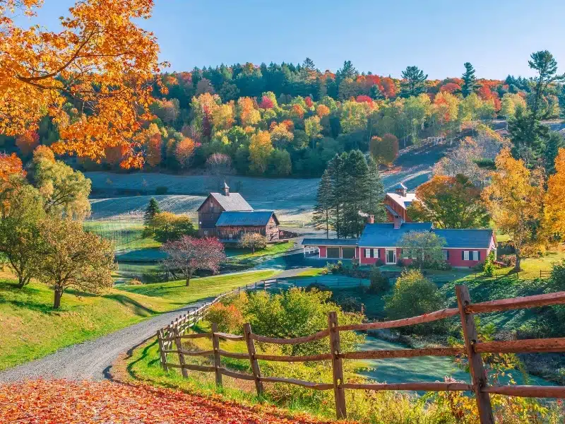 An early autumn foliage scene of houses in Woodstock, Vermont mountains