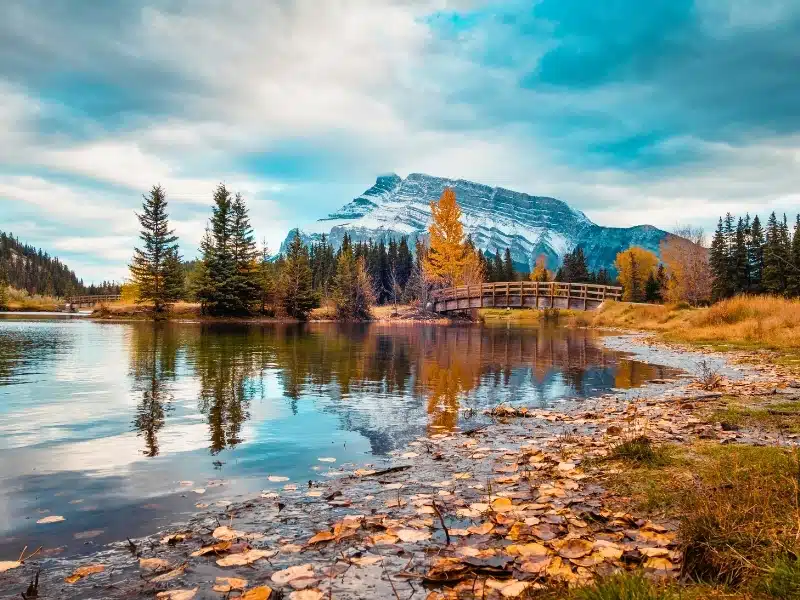 Scenic view of snow capped Mount Rundle reflecting in Cascade Ponds during autumn in Banff National Park, Alberta, Canada