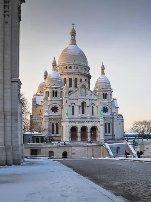 Sacre Coeur Basilica in Montmartre, Paris, framed by a light dusting of fresh snow. 