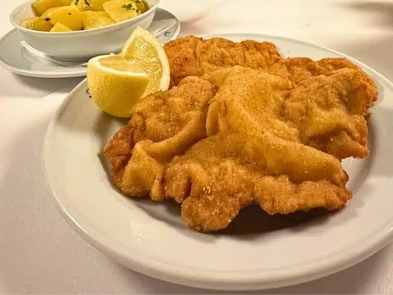 Traditional Wiener schnitzel served with lemon wedges and boiled potatoes