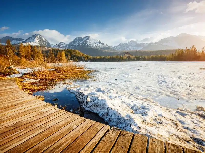 Sunny landscape of a frozen mountain lake on a frosty day. Location place Strbske Pleso, High Tatras national park, Slovakia, Europe. 