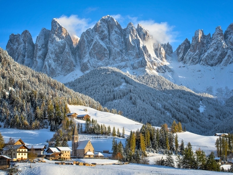 The small village of St. Magdalena or Santa Maddalena with its church covered in snow and with the Odle or Geisler Dolomites mountains in the Val di Funes Valley in South Tyrol in Italy in winter.