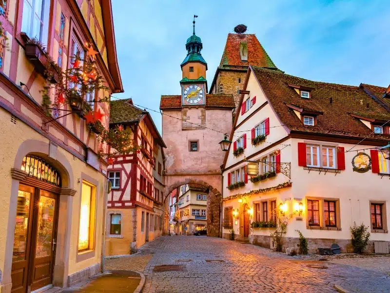 Decorated and illuminated Christmas street with Markusturm gate and tower in the medieval old town of Rothenburg ob der Tauber, Bavaria, southern Germany