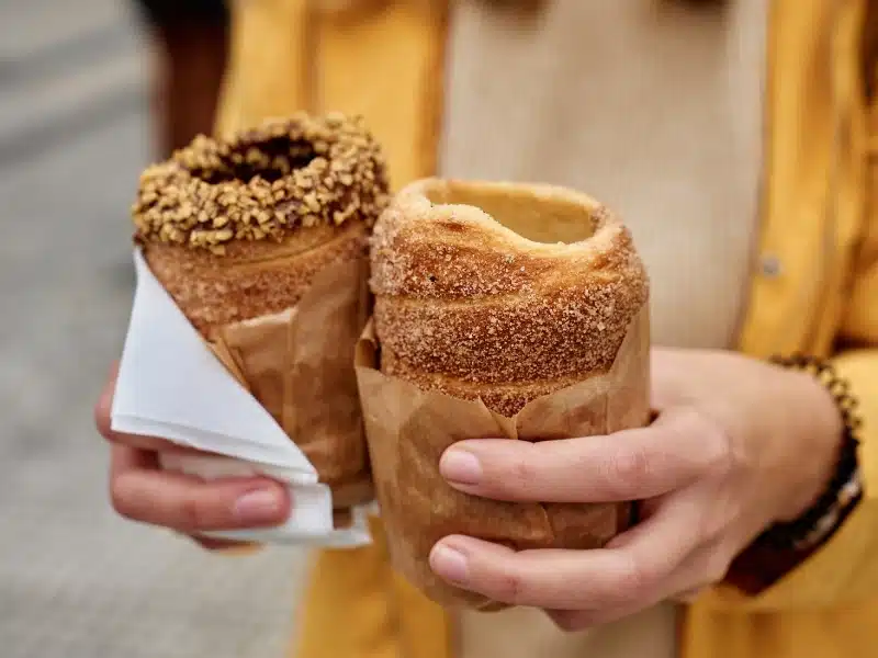 Street food at the Christmas market in Budapest, Hungary - Kurtoskalacs, the national classic pastry, also called Baumkuchen, Trdelnik, Shakotis and chimney cake
