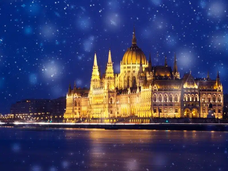 snowing in Budapest, Hungary - winter in the city and the Hungarian Parliament building at night