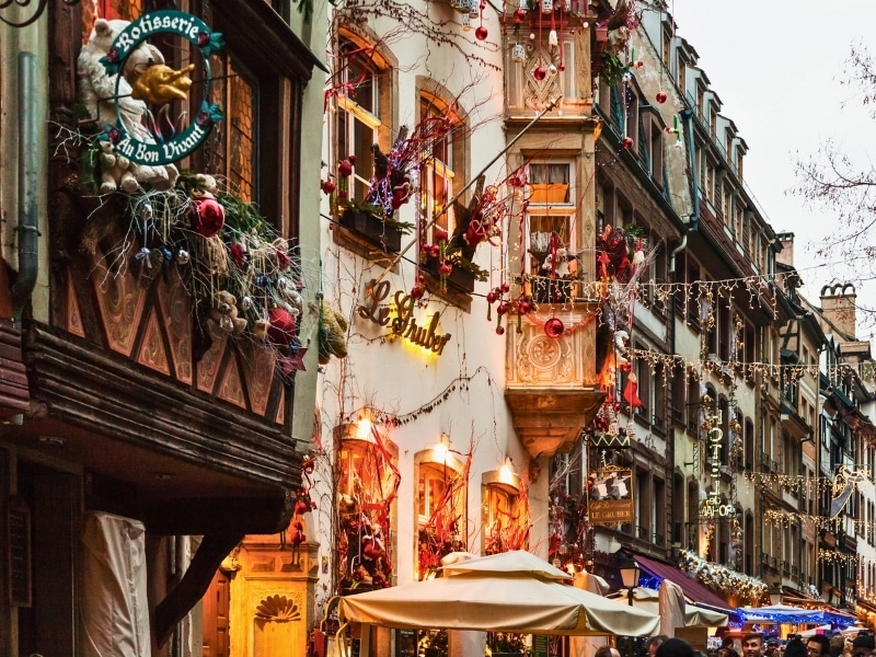 Festive illuminated street during traditional Xmas fair in Strasbourg city. The Strassbourg Christmas market is very first Christmas market in France