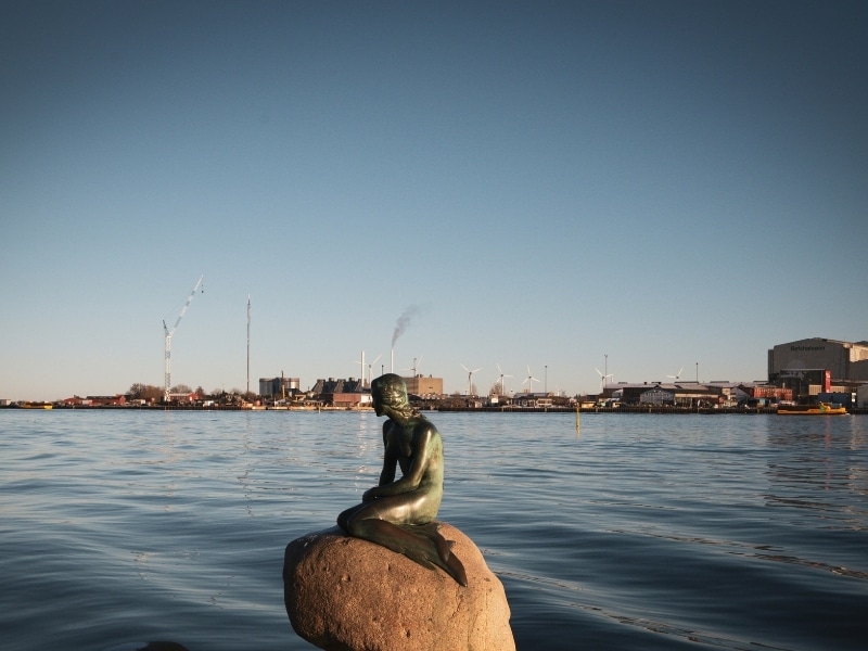Small statue of a rock overlooking a harbour on a sunny winter's day