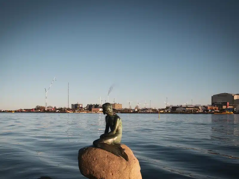 Small statue of a rock overlooking a harbour on a sunny winter's day