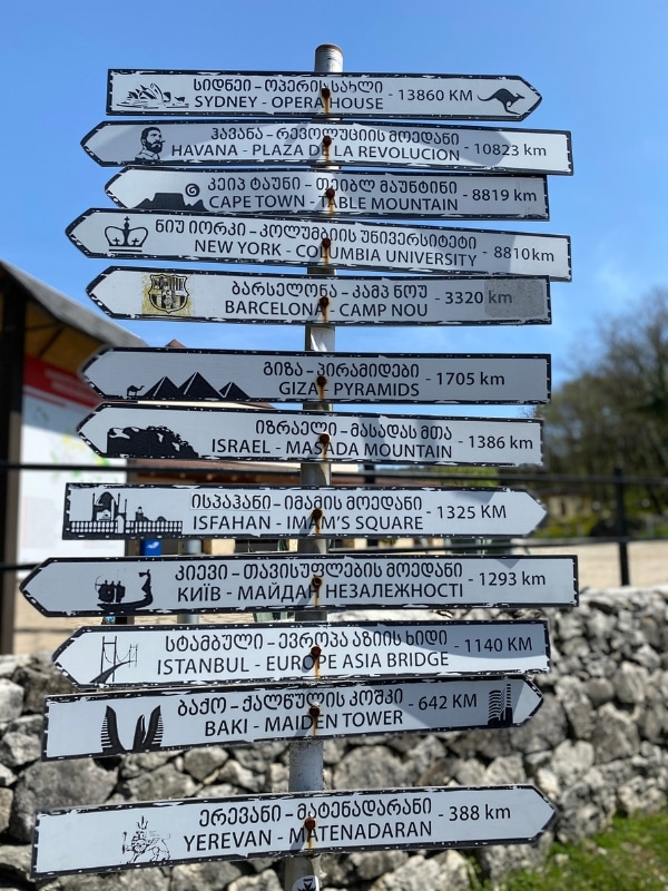 metal sign post totem showing many travel destinations